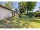 Spacious backyard featuring mature trees and foliage with a patio and barbecue grill at 5 Greenfern Cir, Ormond Beach, FL 32174