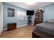This bedroom with blue walls is brightly lit by a large window and has wood flooring at 5 Greenfern Cir, Ormond Beach, FL 32174