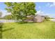 Spacious backyard featuring a lush lawn, swing, shed, and privacy fence at 5478 Landis Ave, Port Orange, FL 32127