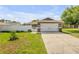 Attractive house featuring attached two-car garage, a well kept lawn, and a white fence at 5478 Landis Ave, Port Orange, FL 32127