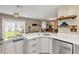 Kitchen island with sink, white cabinets, and view to dining area with natural light at 5478 Landis Ave, Port Orange, FL 32127