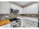 Updated kitchen with stainless steel appliances, white cabinets, and attractive backsplash at 5478 Landis Ave, Port Orange, FL 32127