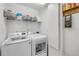 Well-organized laundry room with modern washer, dryer, wire shelf, and storage containers at 5478 Landis Ave, Port Orange, FL 32127