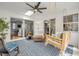 Bright enclosed porch with a wooden swing and an armchair over a blue patterned rug at 5478 Landis Ave, Port Orange, FL 32127