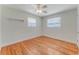Cozy bedroom featuring hardwood floors, ceiling fan, and natural light from two windows at 556 N Beach St, Ormond Beach, FL 32174