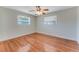 Simple bedroom with hardwood floors, ceiling fan, and natural light from two windows at 556 N Beach St, Ormond Beach, FL 32174