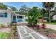 Charming home with a welcoming front yard featuring a stone pathway and a bench to relax on at 556 N Beach St, Ormond Beach, FL 32174