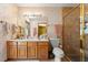 Bathroom featuring a wooden vanity, glass shower, and decorative wallpaper at 5721 John Anderson Hwy, Flagler Beach, FL 32136