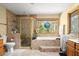 Bathroom featuring a walk-in shower, soaking tub with jets, and a natural garden view, creating a peaceful retreat at 5721 John Anderson Hwy, Flagler Beach, FL 32136