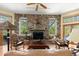 Cozy living room boasts a stunning stone fireplace and ample natural light, ideal for relaxing or entertaining guests at 5721 John Anderson Hwy, Flagler Beach, FL 32136