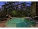 Private screened-in pool with a rock waterfall surrounded by lush greenery at 5721 John Anderson Hwy, Flagler Beach, FL 32136