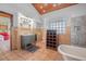 Bathroom features tile floors and walls, a claw foot tub, and wood ceilings at 61 E Bayshore Dr, Port Orange, FL 32127
