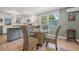 Bright dining area featuring tile floors, modern table set, and views of the kitchen and backyard at 61 E Bayshore Dr, Port Orange, FL 32127