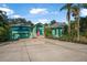 Charming teal home with a pink front door, lush landscaping, and a spacious driveway at 61 E Bayshore Dr, Port Orange, FL 32127