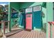 Charming home featuring a vibrant pink front door, teal shutters, and an inviting front porch at 61 E Bayshore Dr, Port Orange, FL 32127