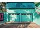 Two-car garage with matching turquoise doors and adjacent pink entrance offers ample parking at 61 E Bayshore Dr, Port Orange, FL 32127