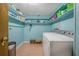 Functional laundry room with washer, shelves, and pale blue walls at 61 E Bayshore Dr, Port Orange, FL 32127