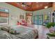 Bright main bedroom featuring tile floors, wood ceiling, and access to the outdoors at 61 E Bayshore Dr, Port Orange, FL 32127