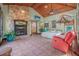 Spacious main bedroom with stone fireplace, wood ceiling, ceiling fan, and an ensuite bathroom at 61 E Bayshore Dr, Port Orange, FL 32127