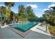 Backyard pool with ample patio space for entertaining, complemented by tropical foliage and lounge seating at 61 E Bayshore Dr, Port Orange, FL 32127