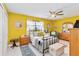 Bright bedroom featuring cheerful yellow walls, ceiling fan, and comfortable furnishings at 625 N Halifax Ave # 11, Daytona Beach, FL 32118