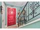 Inviting entryway with a vibrant red door, staircase, and wrought iron railing at 625 N Halifax Ave # 11, Daytona Beach, FL 32118