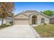 Charming one-story home featuring a beige exterior, attached two-car garage and manicured lawn at 700 Spring Cavern Ave, Orange City, FL 32763