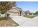 Charming single-story home showcasing a well-maintained lawn and a two-car garage with a concrete driveway at 700 Spring Cavern Ave, Orange City, FL 32763