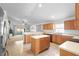 Well-lit kitchen with wood cabinetry, white countertops, an island, and a view to the living room at 700 Spring Cavern Ave, Orange City, FL 32763