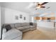 Cozy living room showcasing a comfortable sectional sofa, ceiling fan, and an open view to the kitchen at 700 Spring Cavern Ave, Orange City, FL 32763
