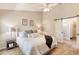 Bright bedroom featuring a ceiling fan, sliding barn door, and en-suite bathroom for added convenience at 706 Fox Tail Ct, New Smyrna Beach, FL 32168