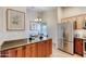Kitchen with stainless steel refrigerator, wood cabinets, granite counters, and dining area at 706 Fox Tail Ct, New Smyrna Beach, FL 32168