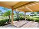 Enjoy a covered patio with brick flooring, overlooking a pond, lush landscape, and mature trees at 706 Fox Tail Ct, New Smyrna Beach, FL 32168