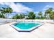Sunny community pool with chairs and tables surrounded by a white fence and lush landscaping at 706 Fox Tail Ct, New Smyrna Beach, FL 32168