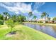 Beautiful water view of the property's backyard featuring lush landscaping and mature palms at 706 Fox Tail Ct, New Smyrna Beach, FL 32168
