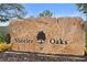 Sheeler Oaks community sign with stone texture and a tree logo at 910 Sheeler Oaks Dr, Apopka, FL 32703