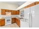 Well-lit kitchen featuring oak cabinets, white appliances, and ample counter space at 910 Sheeler Oaks Dr, Apopka, FL 32703