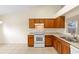 Bright kitchen features wood cabinets, white appliances, and tile floors at 910 Sheeler Oaks Dr, Apopka, FL 32703