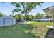 Spacious backyard with a shed, patio furniture, an above-ground pool, and lush greenery at 920 Trafalgar St, Deltona, FL 32725