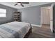 Spacious bedroom with a ceiling fan, light gray walls, a bookshelf, and a bright window at 920 Trafalgar St, Deltona, FL 32725