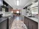 Modern kitchen with dark cabinets, stainless steel appliances, and stone backsplash, open to the living area at 920 Trafalgar St, Deltona, FL 32725