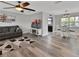 Bright and modern living room featuring gray walls, wood floors, ceiling fan, and contemporary furnishings at 920 Trafalgar St, Deltona, FL 32725
