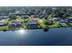 An aerial view shows a lakefront home with a screened-in pool in a residential community at 928 Chickadee Dr, Port Orange, FL 32127