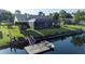 Aerial view of backyard featuring a private dock with boat, screened-in pool, and lush green lawn at 928 Chickadee Dr, Port Orange, FL 32127