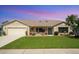 Charming single-story home featuring a manicured lawn, inviting front porch, and attached two-car garage at 928 Chickadee Dr, Port Orange, FL 32127