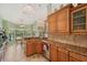 Well-lit kitchen with wooden cabinets, granite countertops, and a view to the pool at 928 Chickadee Dr, Port Orange, FL 32127