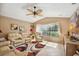 Comfortable living room with ceiling fan, tile floors, and ample natural light from large windows at 928 Chickadee Dr, Port Orange, FL 32127
