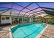 The screened-in pool features a spacious brick patio with sun loungers and a clear view of the home's backyard at 928 Chickadee Dr, Port Orange, FL 32127