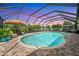 Enclosed pool area with an in-ground pool, brick patio, lounge chairs, and a view of the waterway at 928 Chickadee Dr, Port Orange, FL 32127