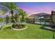 Beautiful pool with screened enclosure, palm trees, and waterfront views, perfect for relaxing and entertaining outdoors at 928 Chickadee Dr, Port Orange, FL 32127